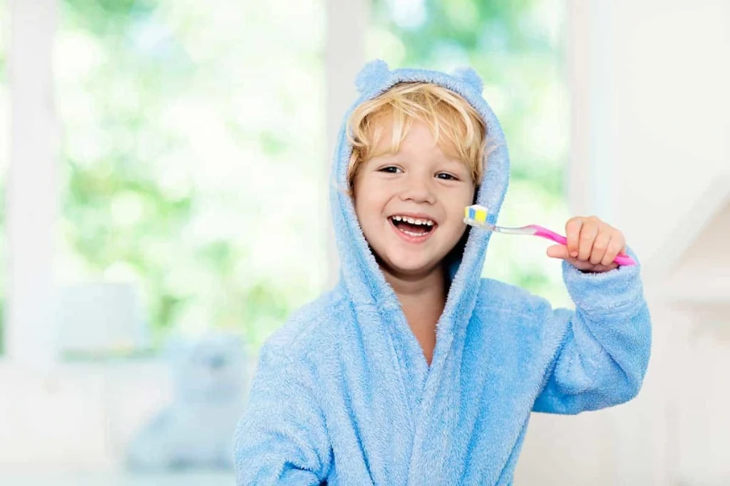 child brushing their teeth after learning what is a pediatric dentist